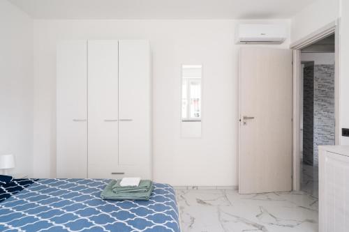 um quarto branco com uma cama com uma toalha em Rifugio Elegante a due passi dal Lago - Free Wifi Giardino e AC em Sarnico