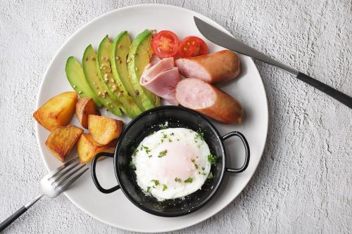 Un plato de comida con un huevo frito y verduras. en OMO7 Yokohama by Hoshino Resorts, en Yokohama