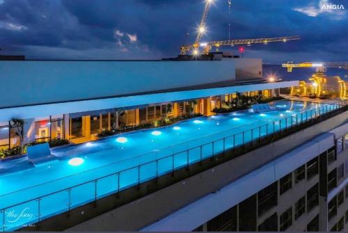 une piscine sur le toit d'un immeuble la nuit dans l'établissement the song aparmert, à Vung Tau