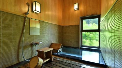 a bathroom with a shower and a toilet and a window at 藤龍館-TOURYUKAN-Yunokamionsen in Yunokami