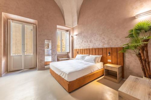 Dimora Suite Oro في غالّيبولي: غرفة نوم فيها سرير و نخلة