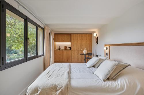 a bedroom with a large bed with a large window at TERRE UGO - Villa & Suites au cœur des lavandes de Provence in Aix-en-Provence