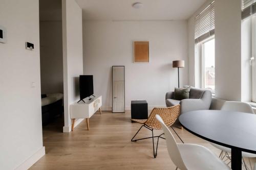 a living room with a table and a couch at Cosy City Apartment in Rotterdam West in Rotterdam