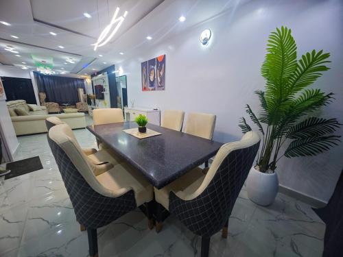 a dining room with a table and a potted plant at Well Furnished 4 bedrooms duplex available! in Lekki