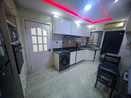 a kitchen with a stove and white cabinets and a red light at Well Furnished 4 bedrooms duplex available! in Lekki