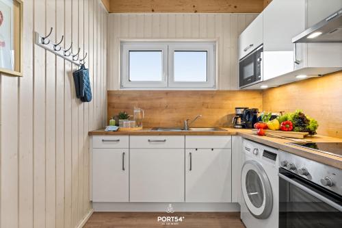 a white kitchen with a sink and a dishwasher at Ferienhaus Südheide Olpenitz in Olpenitz