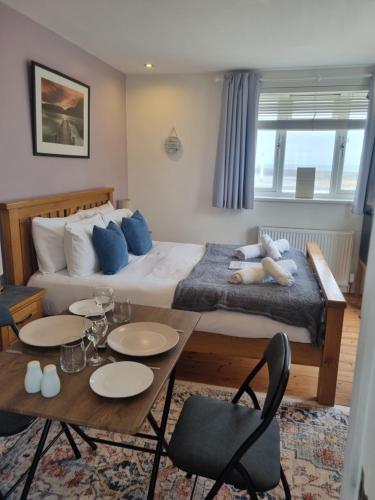 a hotel room with a bed and a table and chairs at Sandy Paws in Portreath