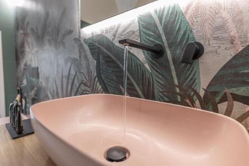 Dimora Suite Argento في غالّيبولي: حمام مع حوض وردي مع صنبور