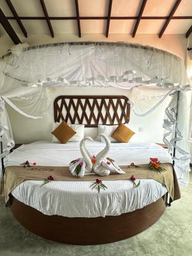 a bedroom with a white bed with towels on it at BAYU COVE Private Villa in Tangalle