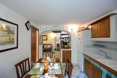 een keuken met een eettafel met stoelen en een wastafel bij Il Paridà in Amalfi