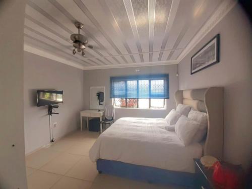 a bedroom with a large bed and a window at The Amazing Amazon Guesthouse in KwaMakhutha