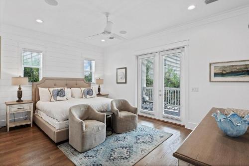 a bedroom with a bed and two chairs and a table at Mermaid Cove in Inlet Beach