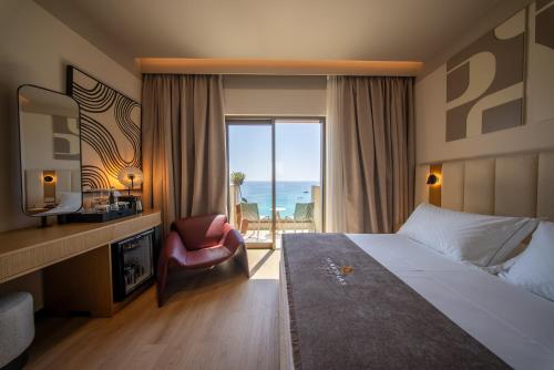 ヒマラにあるSaint Nicolas Hotelのベッドがあり、海が見えるホテルの部屋