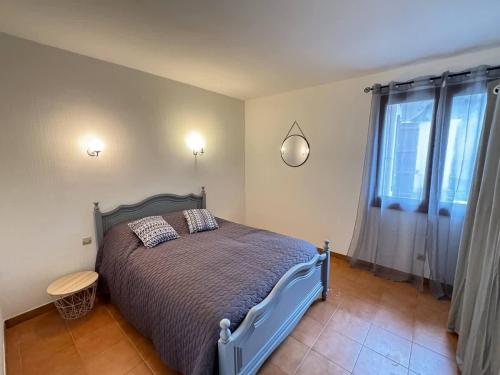 コロンビエールにあるMaison de Village Pres du Canalのベッドと大きな窓のある寝室