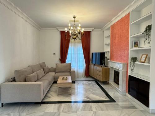 a living room with a couch and a television at Chalet San Francisco in Sanlúcar de Barrameda