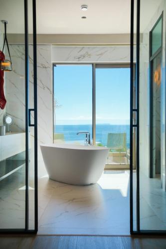 a bath tub in a bathroom with a view of the ocean at Saint Nicolas Hotel in Himare