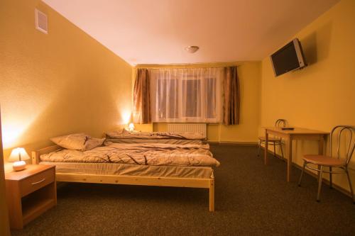 リエパーヤにあるThe Bunker hostelのベッドルーム1室(ベッド1台、テーブル、窓付)