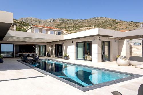 a house with a swimming pool in front of it at Luxury Villa G with private pool and SPA near Dubrovnik in Ivanica