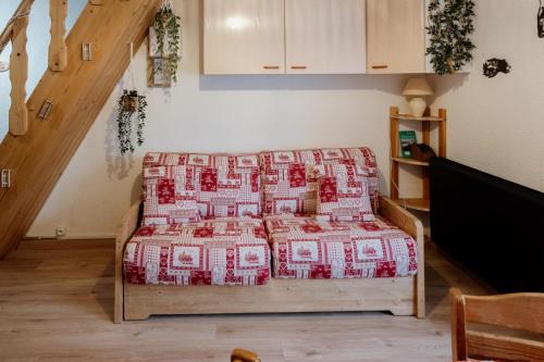 a bed with a red and white quilt in a room at Le Nid des Pistes - Métabief Centre in Métabief