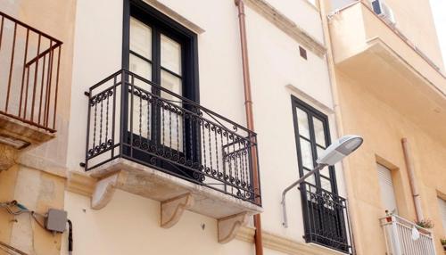 a building with a balcony and a street light at isola felice residence - Family Apartment in Trapani