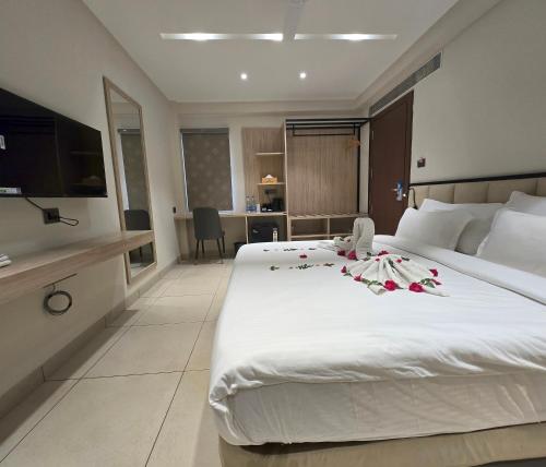 a bedroom with a large white bed with flowers on it at Aarambh By The Sky Imperial Indore in Indore