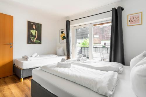 two beds in a room with a window at homy Central City Oasis in Dornbirn in Dornbirn
