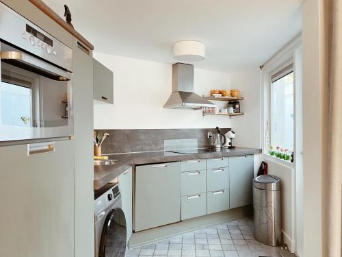 a kitchen with white cabinets and a dishwasher at Oudegracht Alkmaar in Alkmaar