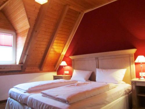 - une chambre mansardée avec un grand lit dans l'établissement Hotel Leinsweiler Hof, à Leinsweiler