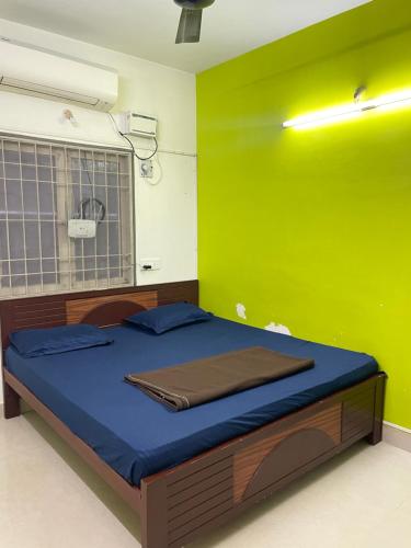 Bett in einem Zimmer mit grüner Wand in der Unterkunft Home stay B1 Groundfloor in Chennai