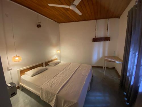a bedroom with a white bed and a ceiling at Nimneth Villa in Ihalagoda