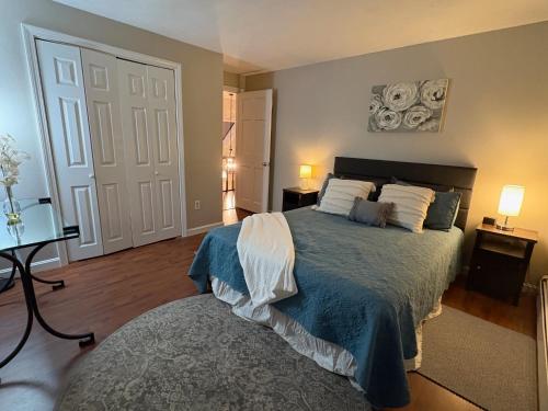 una camera da letto con un letto con una coperta blu e cuscini bianchi di Townhouse on the River a Nottingham