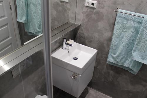 ein Badezimmer mit einem weißen Waschbecken und einem Spiegel in der Unterkunft Casa da Catedral in Porto