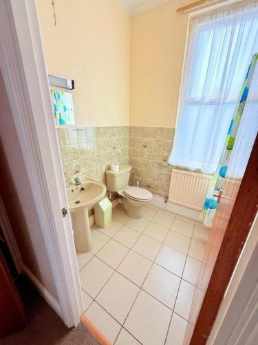 a bathroom with a toilet and a sink at Hylands Hotel Spacious & Bright Triple Room with Ensuite Bathroom and Free Parking in Nottingham