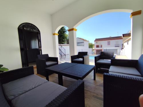 a patio with couches and a table and chairs at Casa Abuela Mercedes & Catalina in Hornachuelos