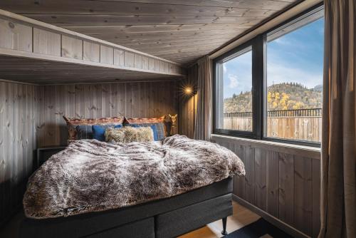 una camera da letto con un letto in una stanza con una finestra di Penthouse with large rooftop terrace, Ski In-Ski Out in Hemsedal a Hemsedal