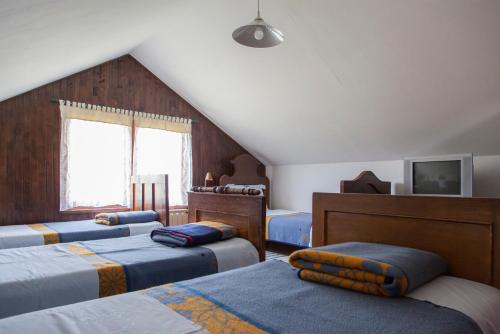 a attic bedroom with four beds and a window at Pension Kezele in Graberje Ivanićko