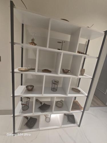 a white shelf with pottery on it in a room at Luxuriöse Ferienwohnung in Manavgat ilica in Ilıcaköy
