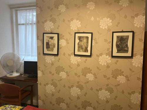 a room with three framed pictures on a wall at Near Hylands hotel family room in Nottingham