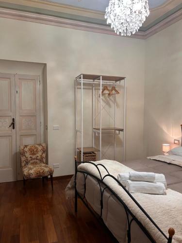 a bedroom with a bed and a chair and a chandelier at Il Palco Centrale in Tolentino