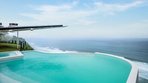 a swimming pool with a view of the ocean at Private Jet Villa on top of the Nyang Nyang Beach Cliff in Uluwatu