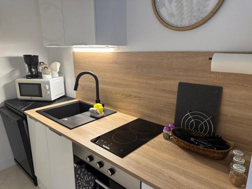 a kitchen counter with a sink and a microwave at La Dolce Vita da Elena - Appartement lumineux à Saint-Raphaël in Saint-Raphaël