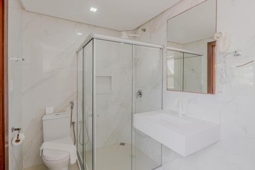 a bathroom with a shower and a toilet and a sink at Pousada Vila Dos Mares in Morro de São Paulo