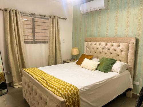 - une chambre dotée d'un grand lit avec des oreillers verts et jaunes dans l'établissement Colonial leyton apartment, à Sans Souci