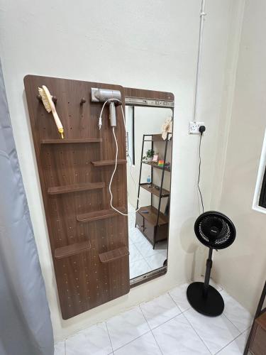 a bathroom with a door with a mirror and a stool at Permaisuri homestay in Bintulu