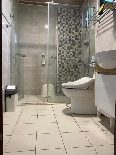 a bathroom with a shower and a toilet and a sink at 鴻源雅居 in Shanhua