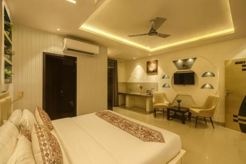 a bedroom with a bed and a table and chairs at The Four Season Resort, Vrindavan- A Hidden Gem Nested In Nature's Lap # By Elegance Group # in Vrindāvan