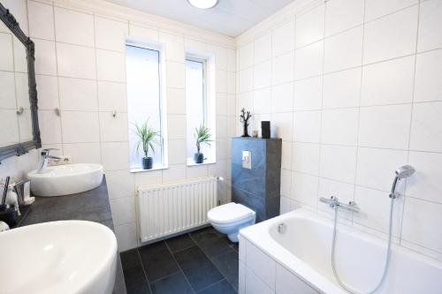 un bagno con vasca, WC e lavandino di Family-Friendly 5BR Home with Free Parking & Balcony a Reykjavik