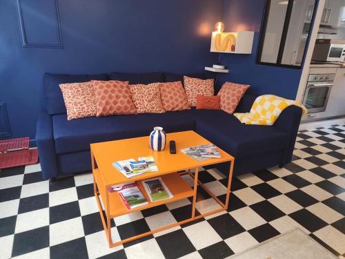 een woonkamer met een blauwe bank en een tafel bij La Fécampette in Fécamp