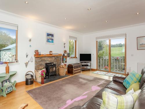 a living room with a couch and a fireplace at East Cottage in Croy