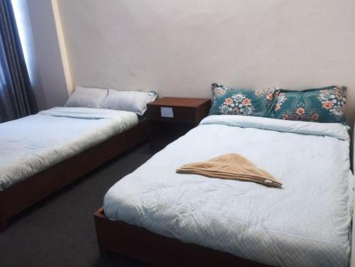 a room with two beds with towels on them at Shree Muktinath Hotel in Pokhara
